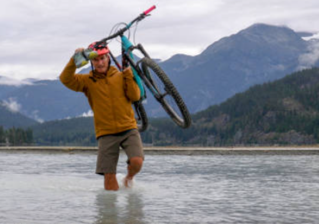 Teacher Carries Bike Across Swollen Stream in Rain-Struck Sirmaur