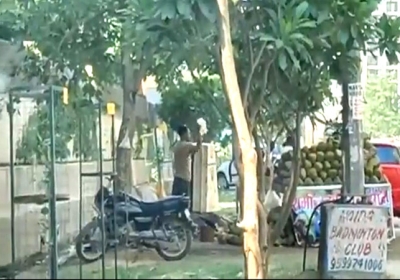 Man Sprinkling Dirty Drain Water on Coconut